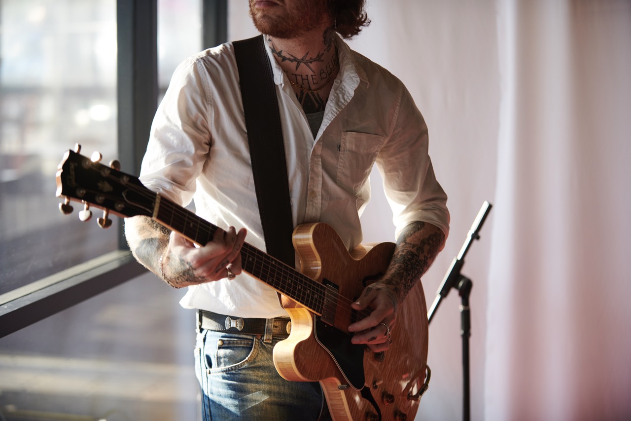 Guitarist performing live music at a local entertainment venue near a residential neighbourhood